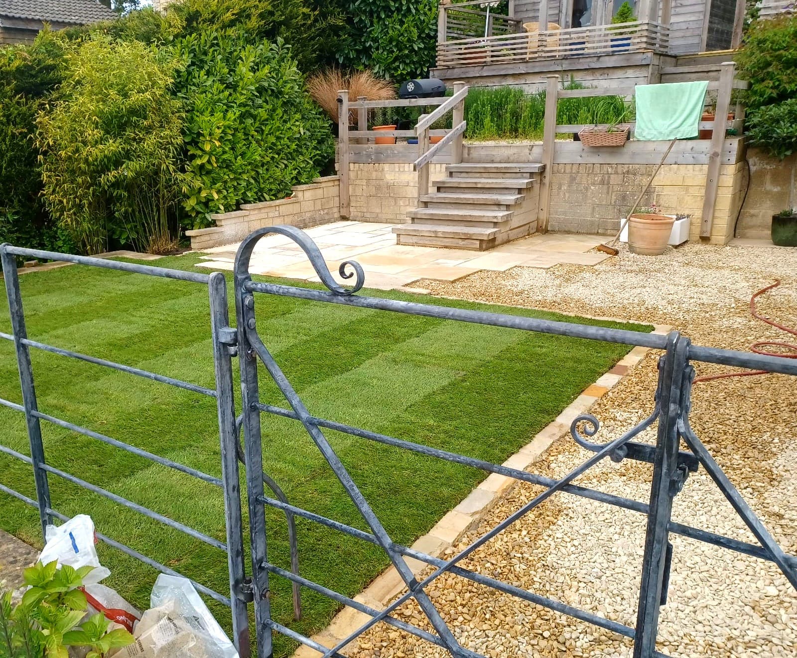 Finished tiered garden with turf, gate and stone steps